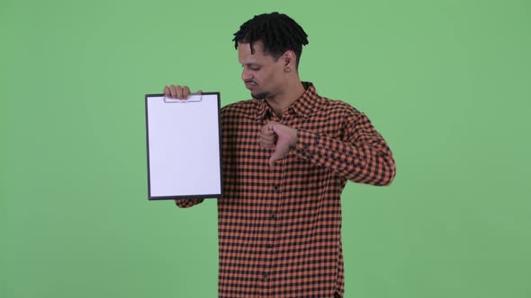 Serious Young African Man Showing Clipboard and Giving Thumbs Down
