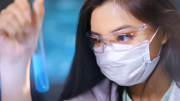 Asian Female Researcher in Protective Glasses Mask Making Chemical Examination of Toxic Substance