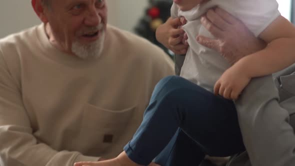 Happy Grandparents Greyhaired Grandpa and Grandma Hug Their Beloved Fouryearold Grandson While