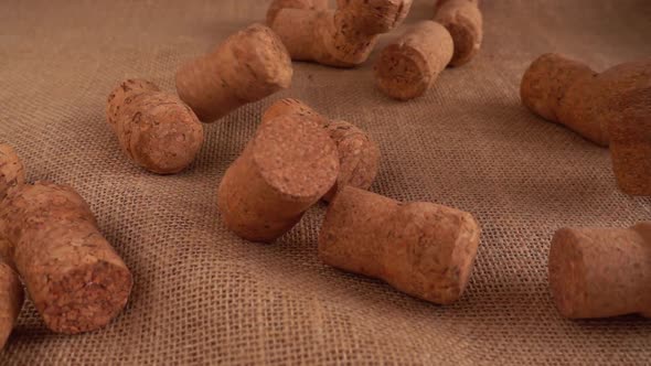 Champagne wine corks fall onto the burlap. Slow motion.