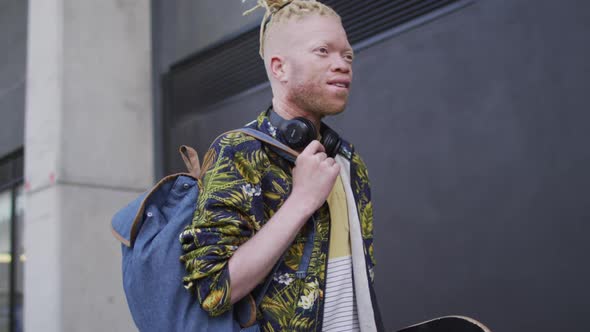 Happy albino african american man with dreadlocks walking