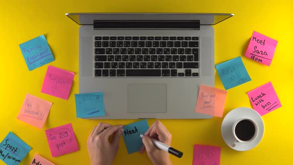 Writing on Post It Papers Making Remind Notes Laptop on Desk Yellow Background