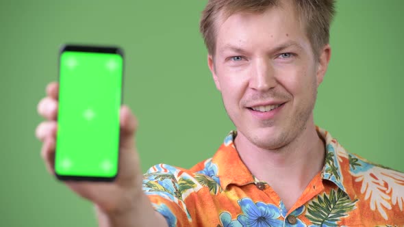 Young Happy Handsome Tourist Man Smiling While Showing Phone