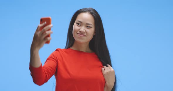 Young Woman Using Smartphone As a Mirror