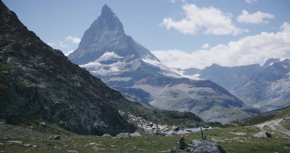 People walking on mountainside landscape surrounding the Matterhorn in Switzerland