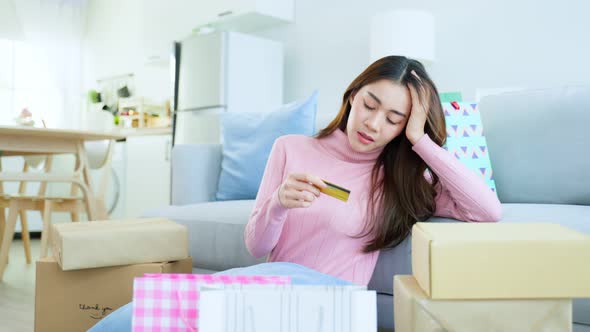 Asian attractive female hold credit card worry about financial problem after shopping.