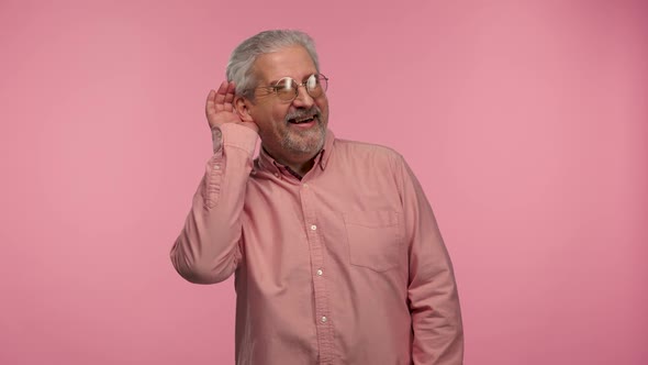 Portrait of an Elderly Man with Glasses Holding Hand Near Ear Trying to Listen to Interesting News
