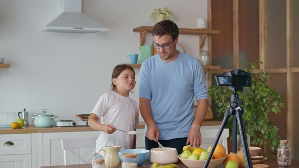 A Father with a Child Is Watching an Online Video Blog