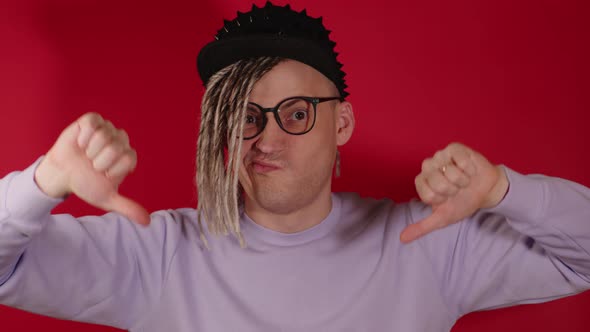 Young Handsome Man in Black Cap Glasses Showing Thumbs Down Looking at Camera