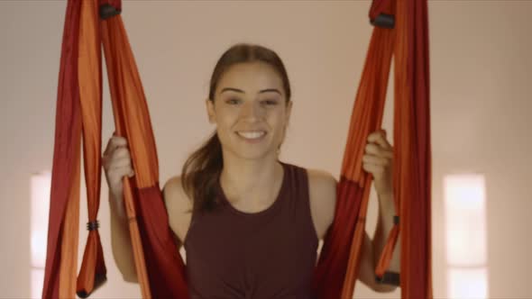Woman Swinging in Hammock at Yoga Studio. Girl Sitting in Hammock for Aero Yoga