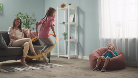 Young Woman Mother with Children Playing in Room Throwing Toys