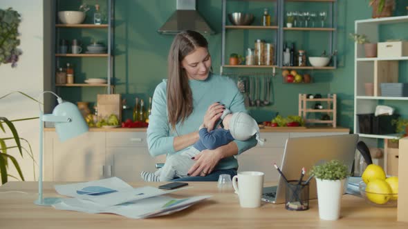 Loving Woman Giving to Drink Milk to Her Son Using a Bottle