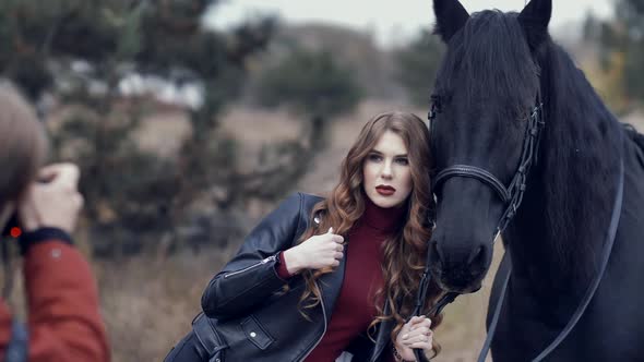 Beautiful Young Woman with Horse Posing for Photographer at Outdoor Photo Shoot