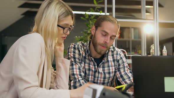 Bearded Man which Talking with Pretty Satisfied Blondie in Glasses During Joint Work