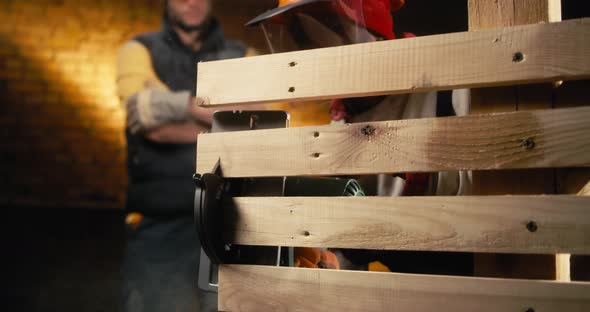 Black Carpenter Cutting Wood Near Supervisor