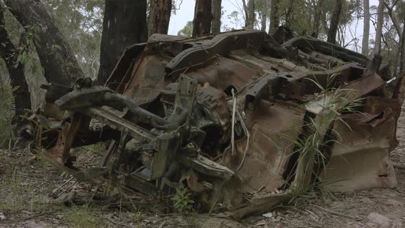 Abandoned flipped car in Australian bushland front on low angle truck right.