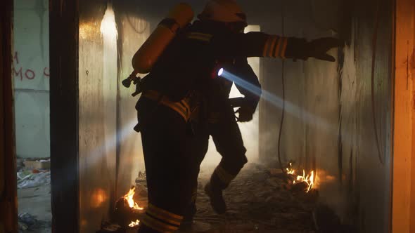 Firefighters Running Through Hallway of Burning Building