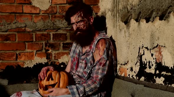 Male Zombie with Pumpkin Looking at Camera. Halloween Theme.