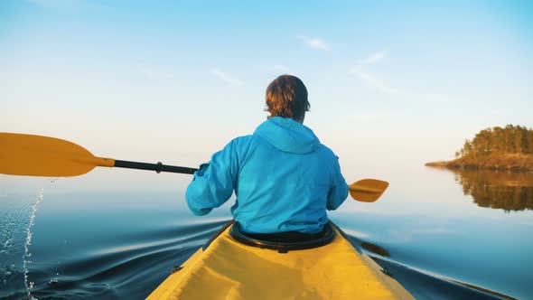 Outdoor Activities, Man Kayaking on a Calm Lake at Sunset