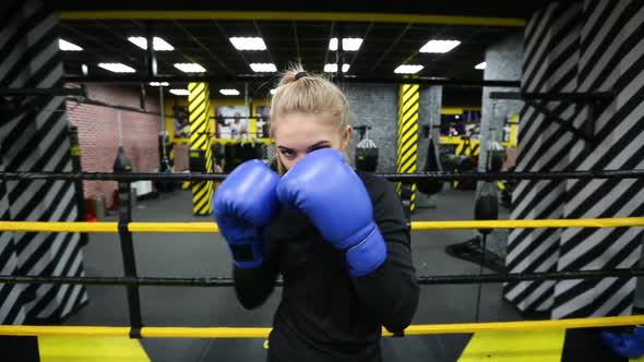 Young Athletic Boxer Girl Hits the Camera with a Glove
