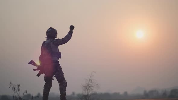 Soldier hold gun and show action of successful or win war by raise his hand and shake