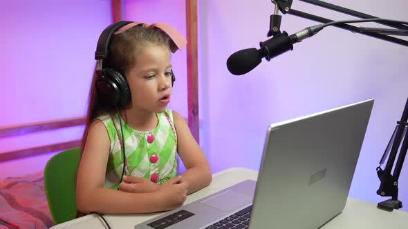 Influencer girl recording podcast and video call in her room with microphone and laptop