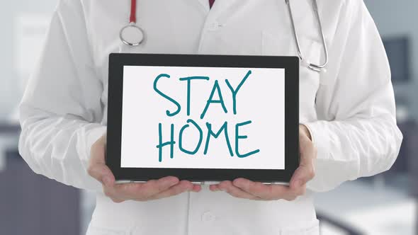Doctor's Hands Holding Tablet PC with STAY HOME Message