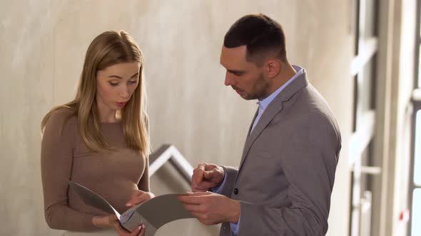 Businesswoman and Businessman Discussing Folder