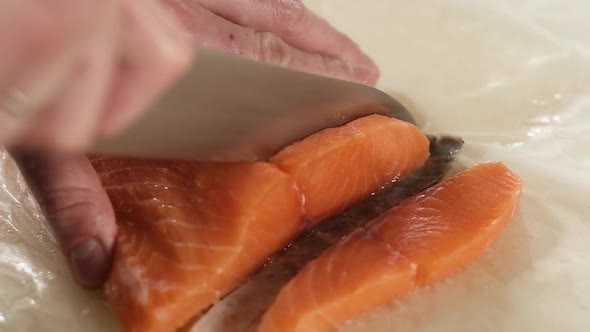 cook cuts fish salmon on cutting Board slices. delicious seafood food. Top view