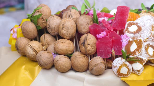 Close-up of a sweet edible bouquet collected from walnuts, marshmallow, figs, dried fruits, prunes, 