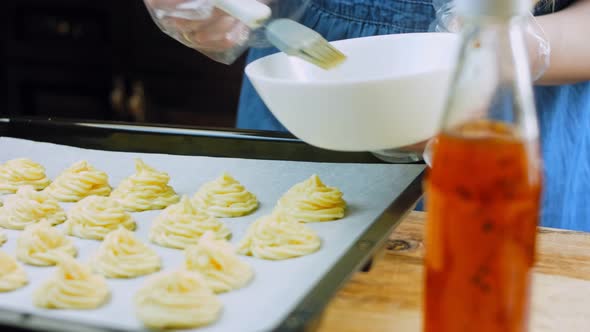 The Chef Greases the Potato Cookies with Oil with a Brush