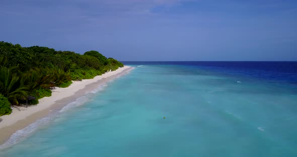 Natural flying copy space shot of a white sandy paradise beach and blue sea background in 4K