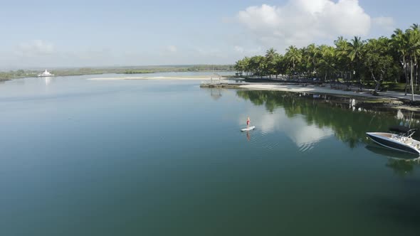 Aerial view of a blonde girl paddling a surfboard, Mauritius.