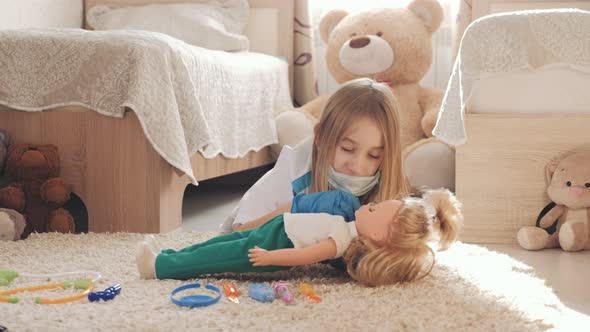 Beautiful Little Girl Playing Doctors with Doll at Home