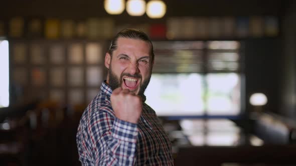 Thrilled Bearded Happy Man Gesturing Victory Gesture Looking at Camera Smiling