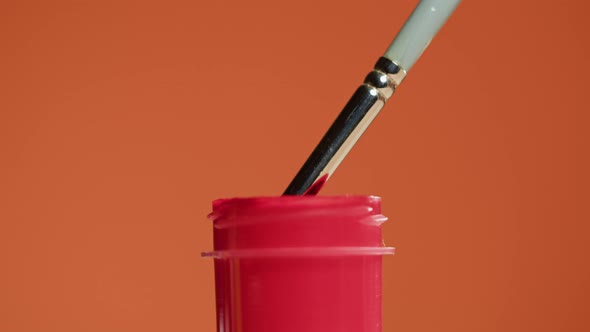 Red Paint Isolated on Orange Background alt