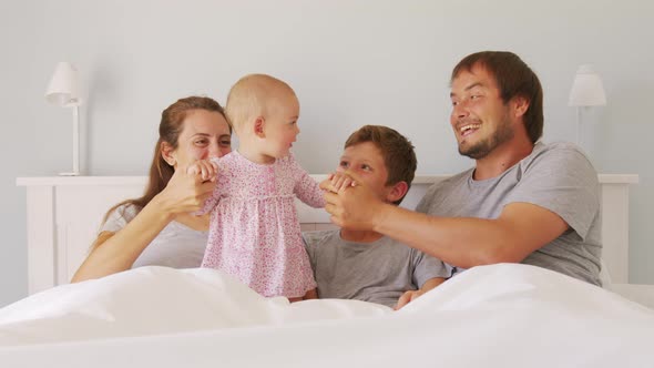 Happy Family with Cute Little Kids Son Daughter Tickling Having Fun Relax on Bad Together Young