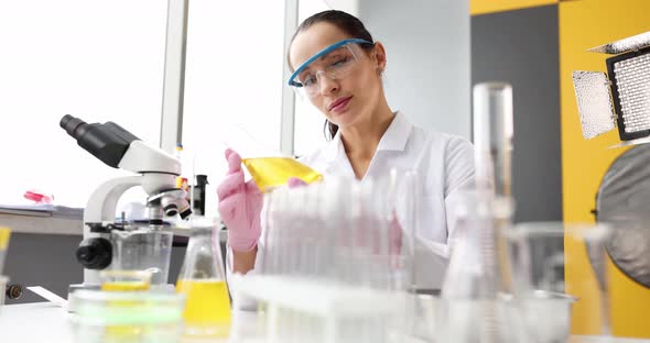 Scientist Holding Flask with Yellow Liquid in Laboratory