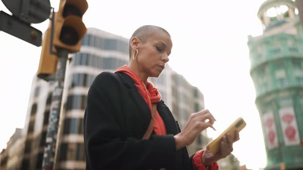 Concentrated bald woman looking at the map on phone