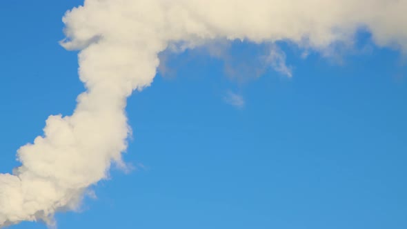 Thick White Smoke Slowly Rises From the Chimney Like White Clouds