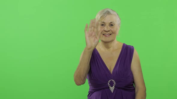 An Elderly Woman Waving To Camera and Smiles. Old Grandmother. Chroma Key