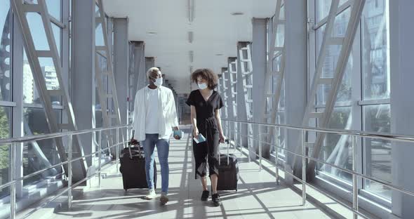 Fulllength Footage African American Couple Friends Colleagues in Medical Masks and with Suitcases