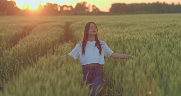 Young Beautiful Asian Woman is Walking Alone on Rye Field in Sunrise or Sunset Portrait  Prores