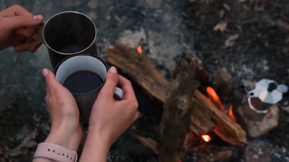 Slow motion 2x Couple in love Campsite With Fire Pit and Two Tin Cups with hot tea, coffee. Burning 