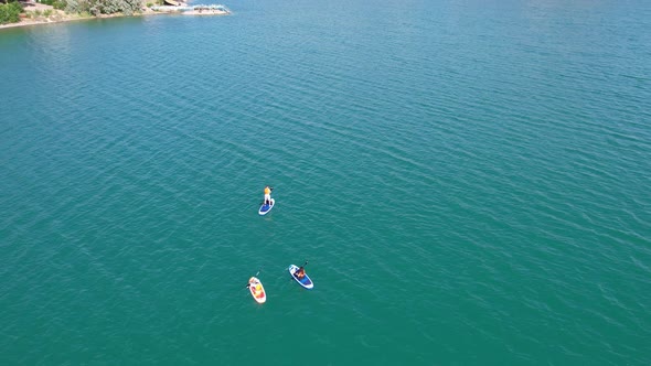 A Group of People Ride Sup Surfing in the Lake