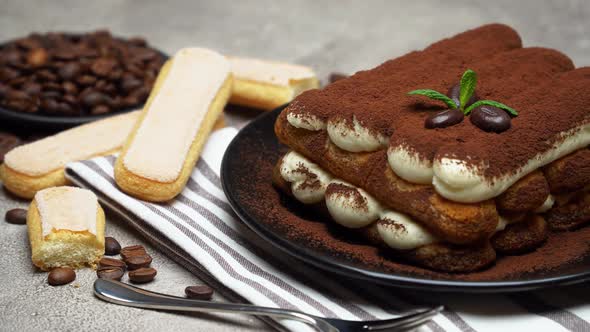 Classic Tiramisu Dessert and Savoiardi Cookies on Ceramic Plate on Concrete Background