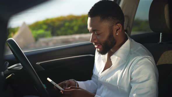 Absorbed African American Handsome Gay Man Texting on Smartphone in Social Media