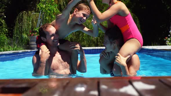 Happy family having fun in swimming pool