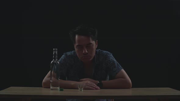 Drunk Asian Man With Vodka Looking At Camera In Black Background