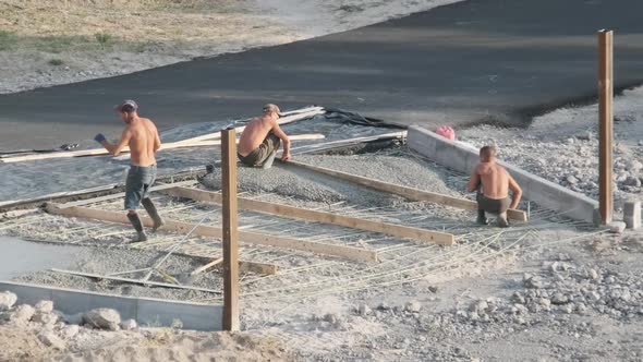 Workers at a Construction Site Leveling Liquid Concrete Outdoor